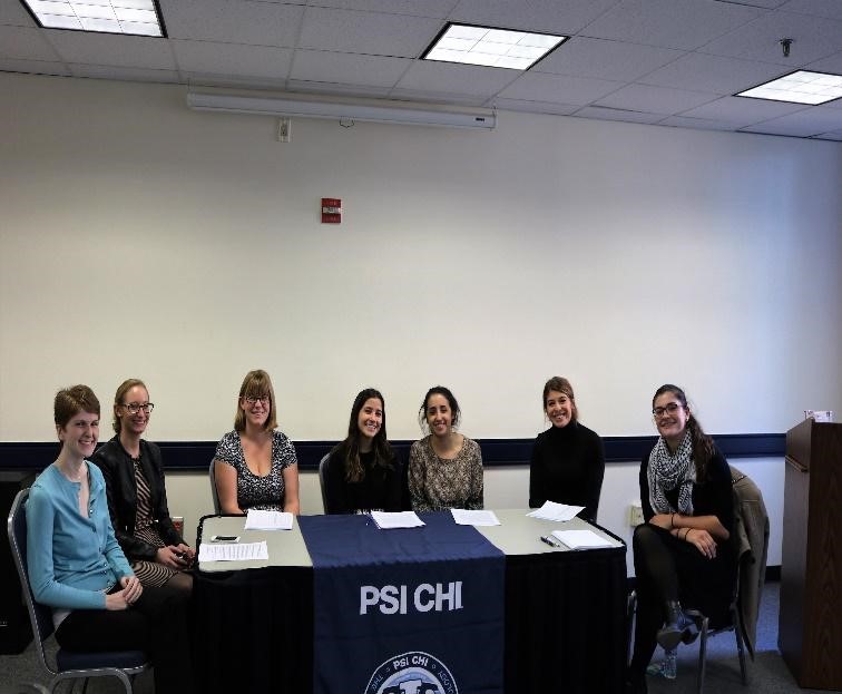 seated group of Psi Chi members at a table