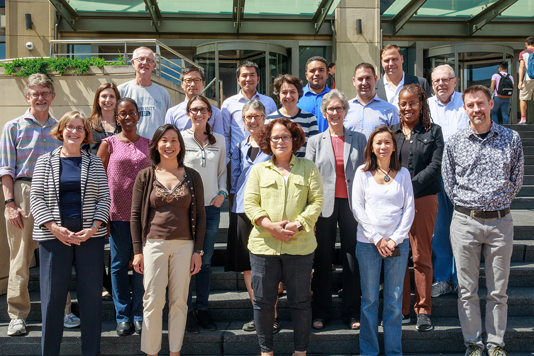 A group of the Psychological and Brain Sciences Department faculty members standing on the stairs outside Gelman Library