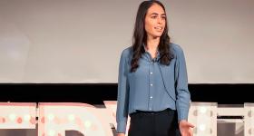 Fallon Goodman stands on stage and presents her TED Talk
